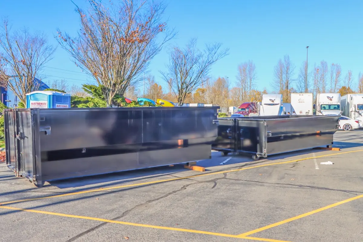 Professional dumpster rental service with roll-off container on residential driveway in Rogersville